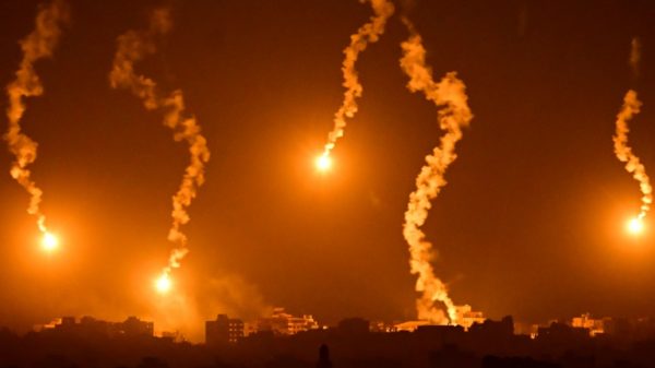 Flares dropped by Israeli forces illuminate the night sky above the Gaza Strip