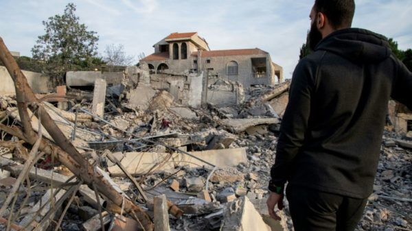A man examines a destroyed building on Monday after an Israeli air raid in the Lebanese village of Kfar Kila