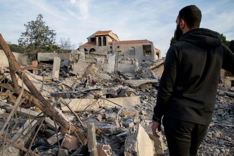 A man examines a destroyed building on Monday after an Israeli air raid in the Lebanese village of Kfar Kila