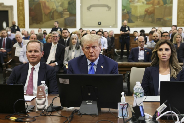 Former US president Donald Trump sits with his attorneys during the opening day of a civil fraud case brought by New York Attorney General Letitia James