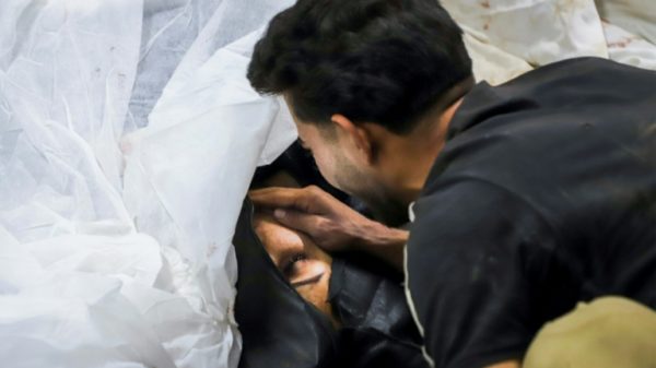 A man mourns a victim, at a hospital in the southern Iranian city of Kerman