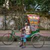 Bicycle rickshaw driver Mohammad Harun poses for a portrait with his vehicle on a street in Dhaka