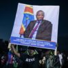 An opposition supporter at a rally in Goma last month with a poster of Cherubin Okende, who was gunned down in July