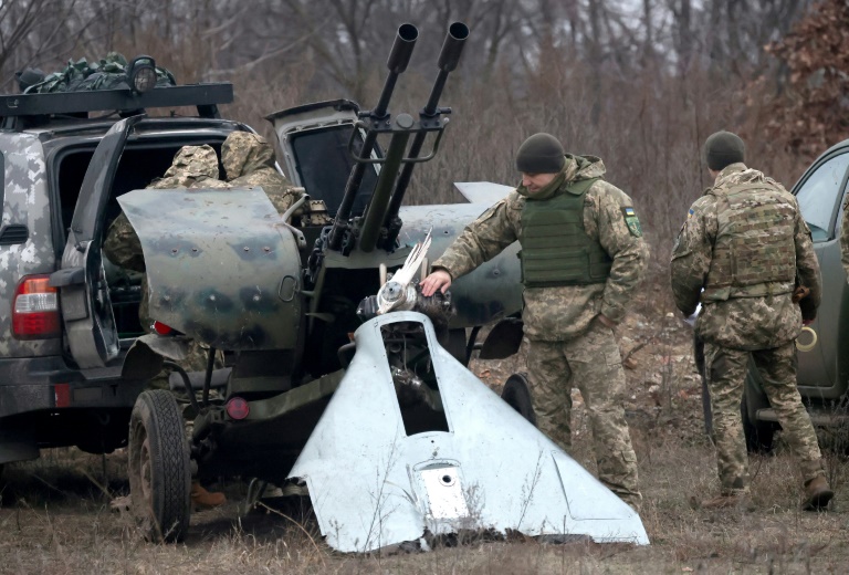 A Ukrainian Air Defence serviceman looks at pieces of a destroyed attack drone near Kyiv