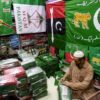 A shopkeeper in the Pakistan port city of Karachi arranges flags of political parties for sale ahead of next month's election
