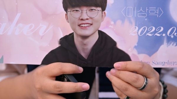 A fans shows off memorabilia of South Korea’s eSports player Lee Sang-hyeok, also known as Faker