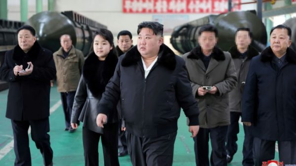 North Korea's leader Kim Jong Un (C) inspects a missile launcher production facility with his daughter Ju Ae (centre L)