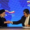 Iranian President Ebrahim Raisi (L) and Venezuelan President Nicolas Maduro shake hands during a joint press statement at Miraflores Presidential Palace in Caracas