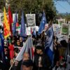 Demonstrators hold flags and placards during a 'No on APEC' protest on November 12, 2023 ahead of the summit in San Francisco