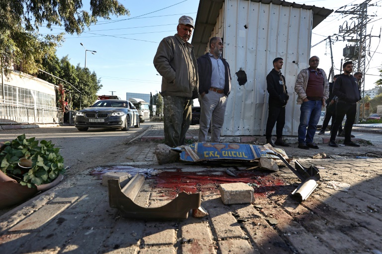 People look at a pool of blood where one six Palestinians was killed during an Israeli raid in Jenin, the occupied West Bank