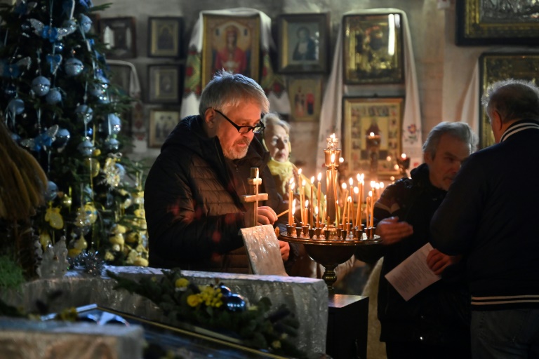 A man lights a candle during an Orthodox Christmas service at St John the Theologian Church in Kharkiv