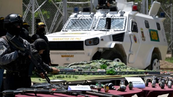 Venezuelan authorities show off the weapons they seized when they stormed the gang-held Tocoron jail with 11,000 police and soldiers