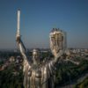 Steeplejacks wave the Ukrainian flag after finishing installing the coat of arms of Ukraine on the shield of the 62 metre Motherland Monument in Kyiv