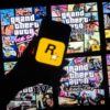 This illusttation shows a logo of Rockstar Games on a smartphone screen and covers of video game series Grand Theft Auto (GTA) on a TV screen in New York, November 27, 2023