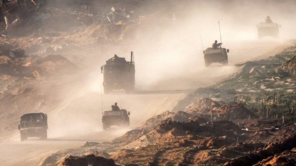 Israeli army vehicles move along a road in the Gaza Strip near a position along the border with southern Israel on Thursday