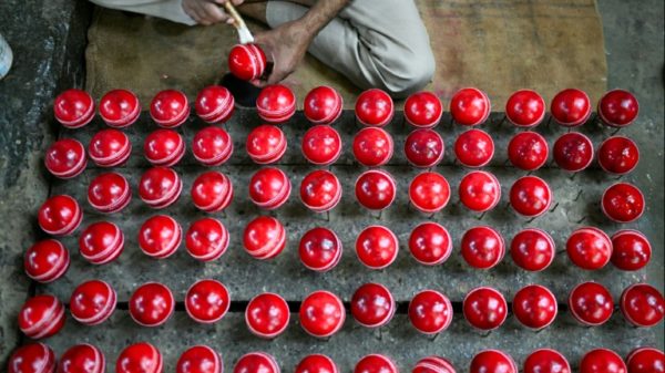 In this photograph taken on September 14, 2023, a worker polishes cricket balls at a workshop in Meerut in India's northern state of Uttar Pradesh