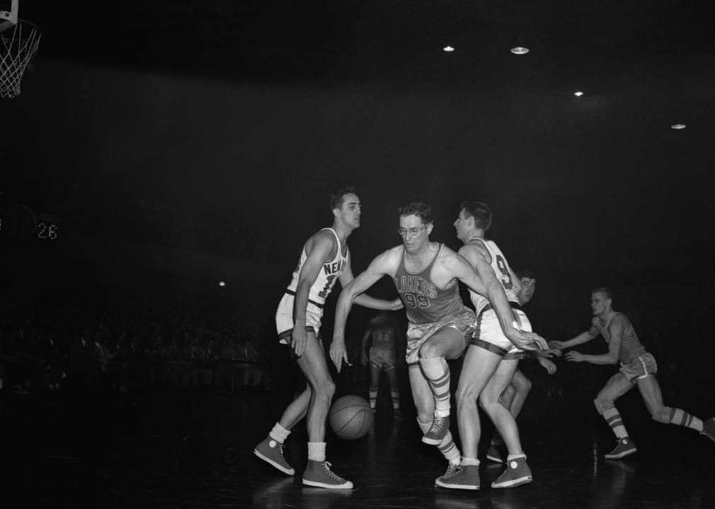 George Mikan of the Minneapolis Lakers coming through center of Connie Simmons during the NBA playoff in 1953.