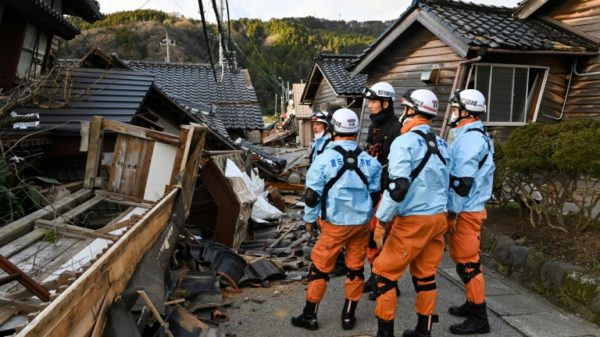 Firefighters inspect collapsed wooden houses in the city of Wajima on Japan's Noto Peninsula, the area hardest hit by the New Year's Day earthquake