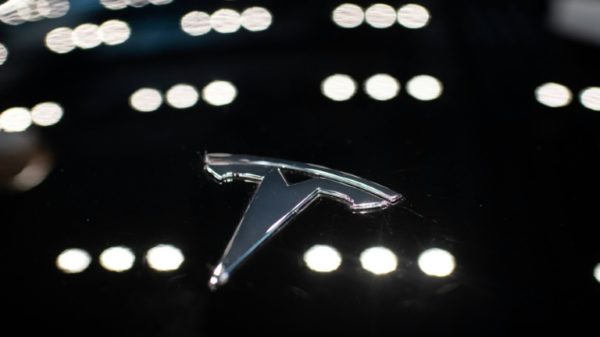 A Tesla logo is seen on a car at a dealership in Beijing