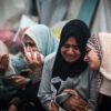 Palestinians mourn their relatives, killed in an overnight strike on the Al-Maghazi refugee camp, during a mass funeral at the Al-Aqsa hospital in Deir Al-Balah, in the central Gaza Strip, on December 25, 2023