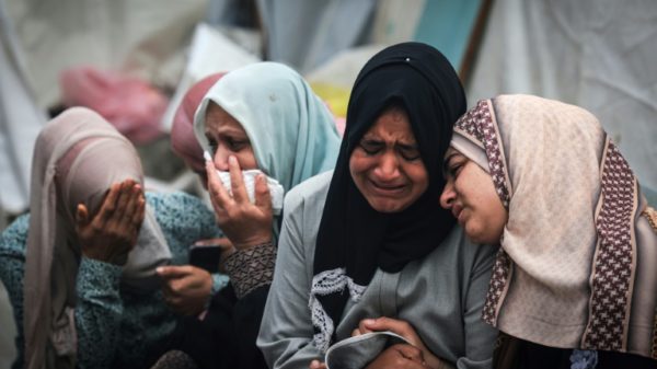 Palestinians mourn their relatives, killed in an overnight strike on the Al-Maghazi refugee camp, during a mass funeral at the Al-Aqsa hospital in Deir Al-Balah, in the central Gaza Strip, on December 25, 2023