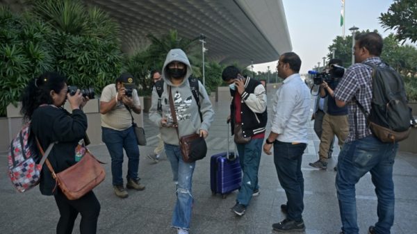 Passengers (C) arriving from France refused to speak to waiting journalists at Mumbai airport